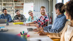 A group of business owners sit around a table discussing options to set up a buy-sell agreement for their closely held business.