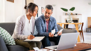 A husband and wife review their receipts and documents for the business they own together to prepare for taxes.