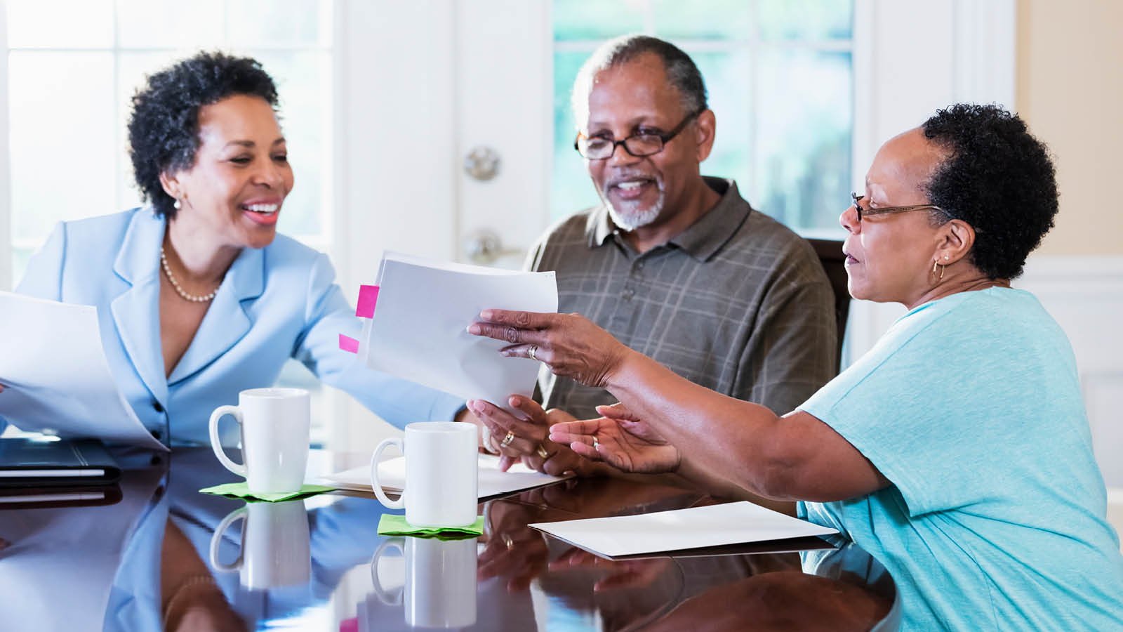 A retired couple meets with their financial professional to discuss the benefits of tax deferral in their financial strategies.