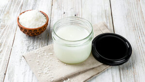 Coconut oil cream on bowl on white wooden table