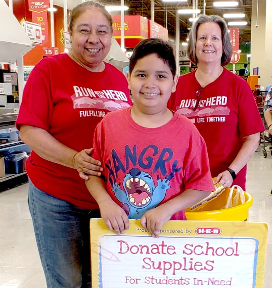 Ameritas associates and child collecting school supplies for the community.