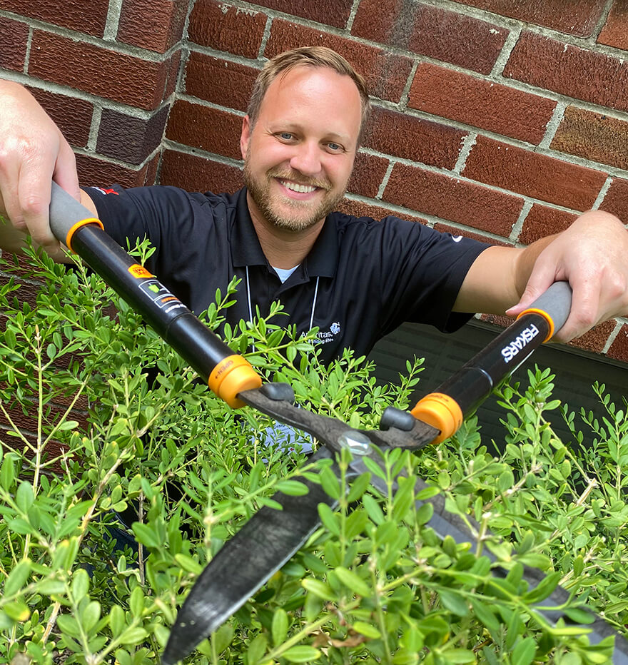Ameritas associate helping out in the community by trimming hedges.