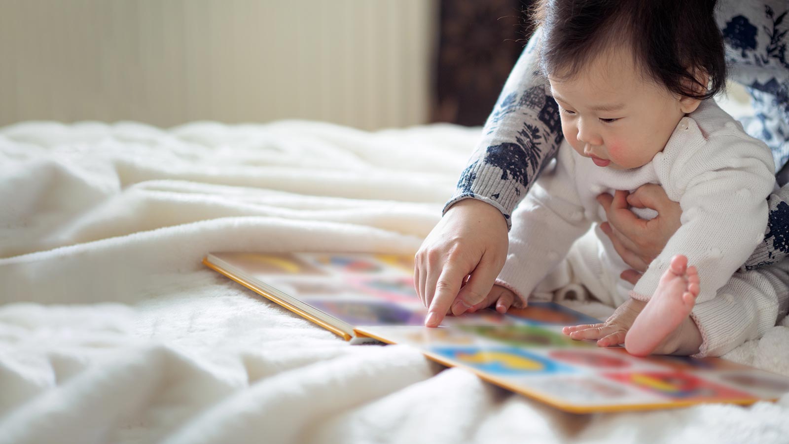 Parent and child looking at a book together.