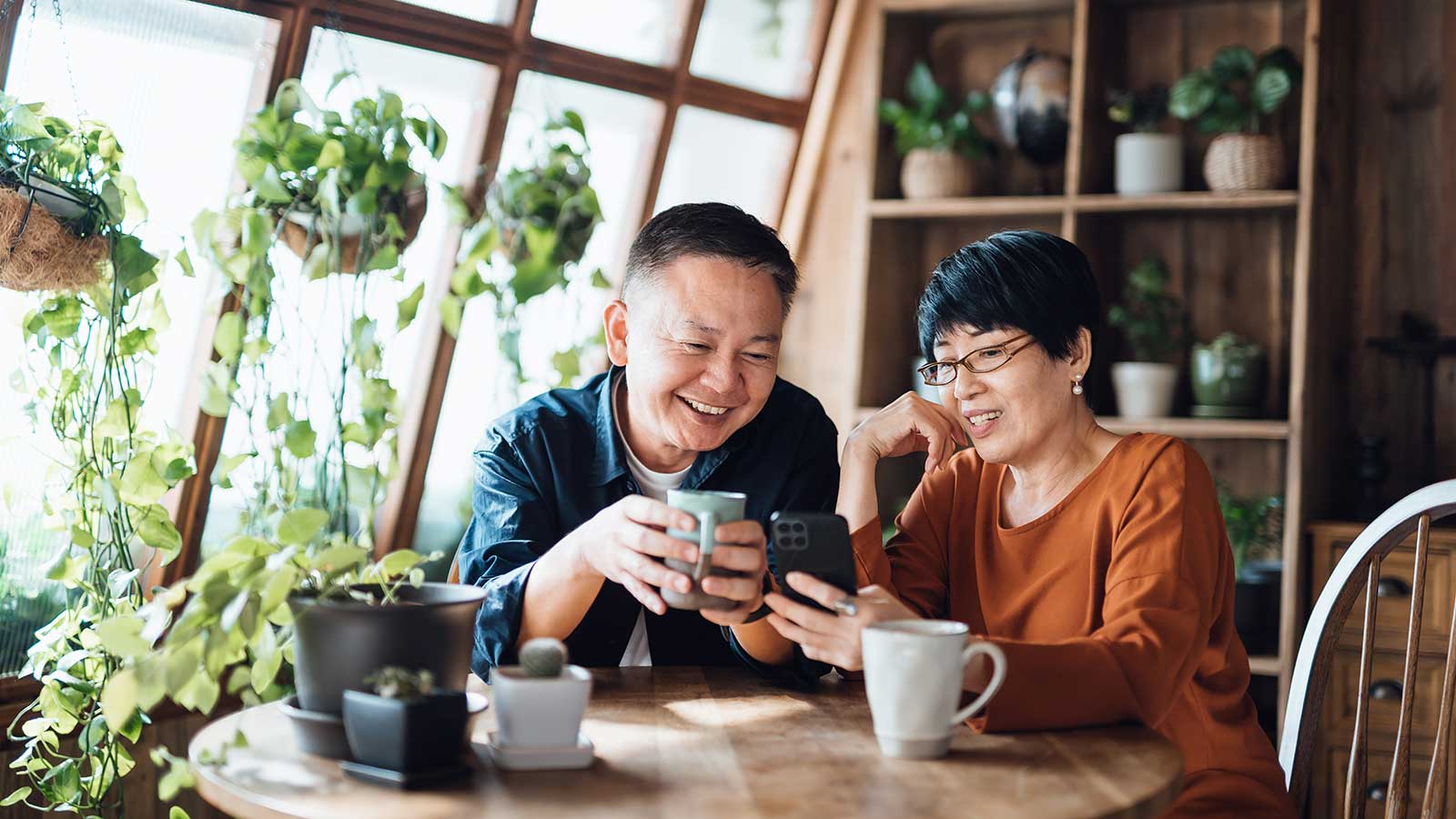 A couple sitting at a table sharing a cup of coffee and enjoying each other's company.