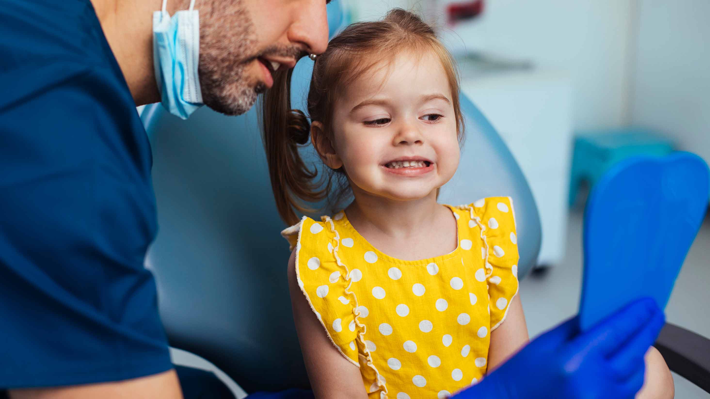 Young girl looking at mirror after having check up.