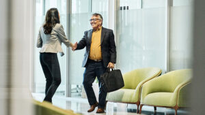 A financial professional meets with a plan sponsor client in her office to review their retirement plan offerings.