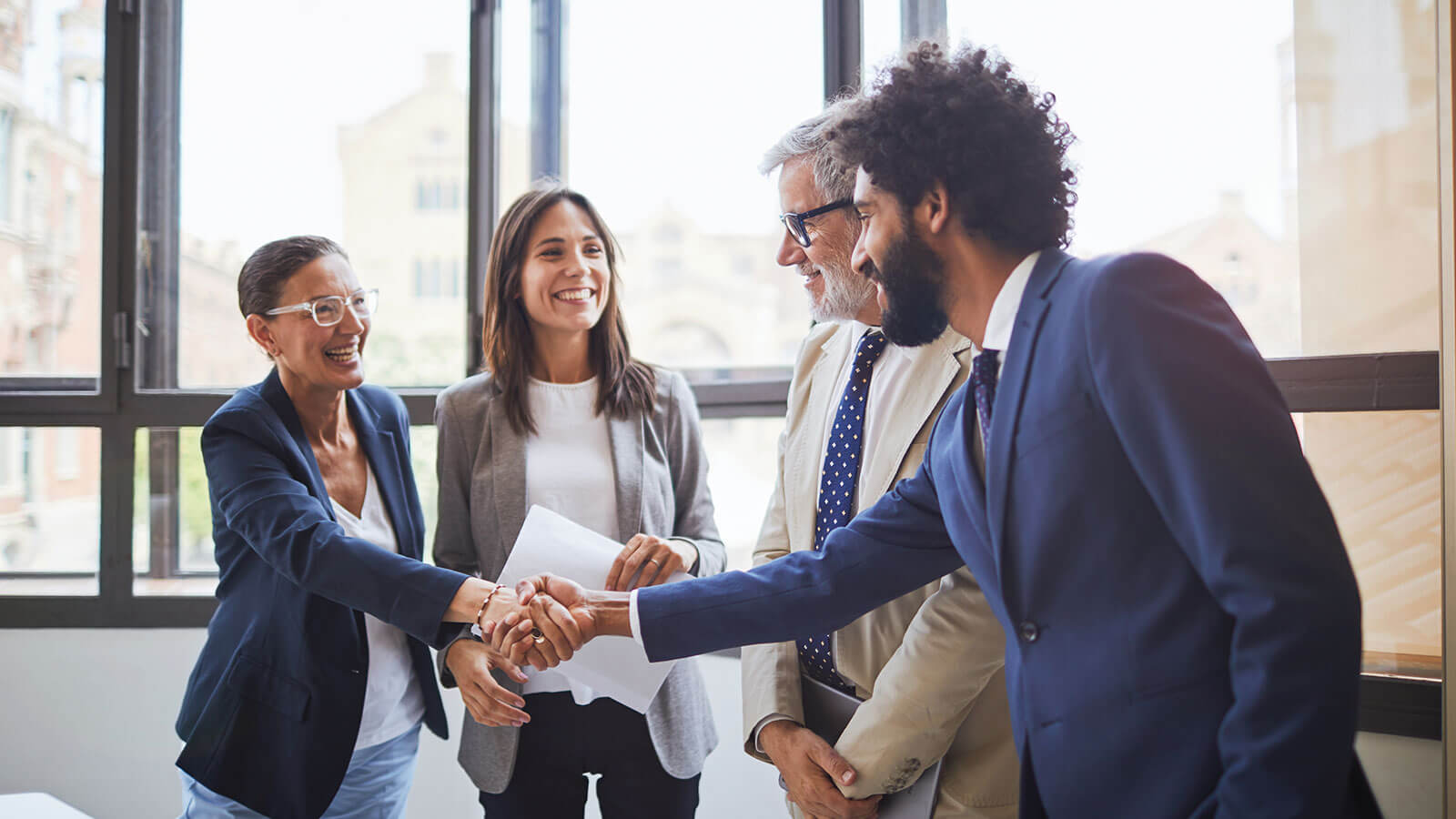 Small group of business professionals shaking hands.