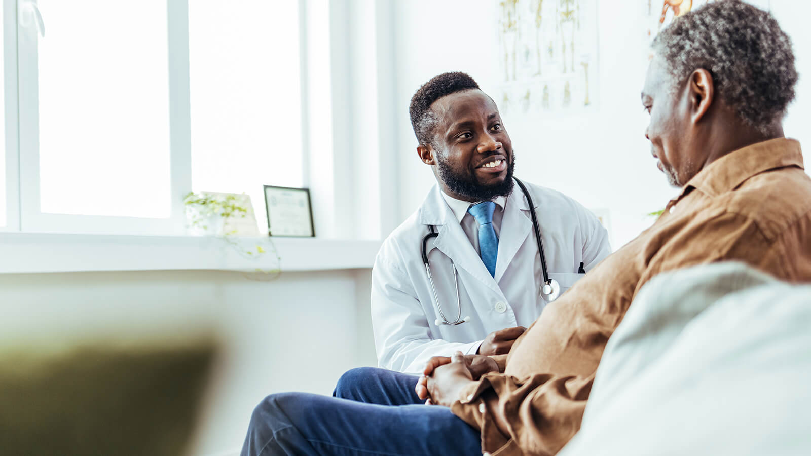 A man in his 70s meets with his doctor to discuss his ongoing treatment and thinks about how he’s going to pay for a serious illness in his retirement years.