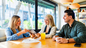 A married couple meets with their financial professional to learn about the differences in permanent life insurance versus term life insurance.