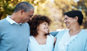 Three individuals laughing and enjoying each other's company outdoors.
