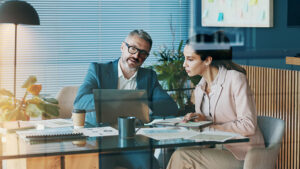 A business owner meets with her financial professional to go over updated SECURE Act 2.0 rules for her retirement plan.
