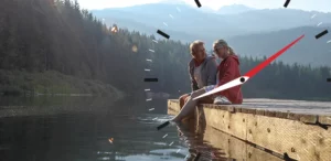 Couple sitting on a dock putting their feet in the water.